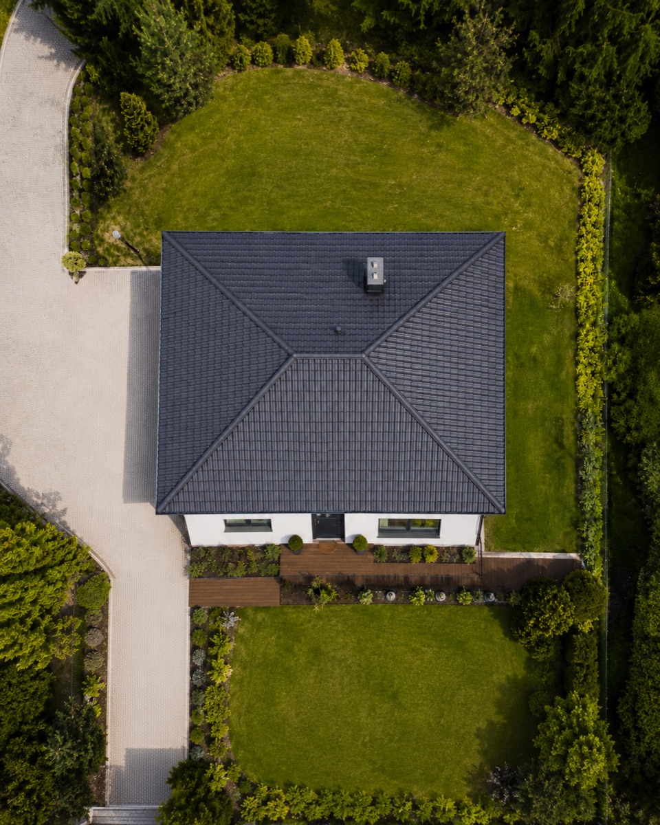 Kolmý pohled dronem na střechu rodinného domu — patrné jsou hřebeny, úžlabí i komín